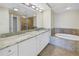 Double vanity bathroom with granite countertop and a bathtub at 1350 Gulf Blvd, Clearwater, FL 33767