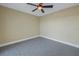 Spacious bedroom with ceiling fan, gray carpeting, and neutral walls at 1350 Gulf Blvd, Clearwater, FL 33767