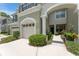 Townhome exterior featuring walkway, landscaping, and attached garage at 14215 Waterville Cir, Tampa, FL 33626