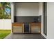 Modern outdoor kitchen featuring granite countertops and a wine cooler at 1905 W Erna Dr, Tampa, FL 33603