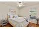 Cozy bedroom with light wood flooring, ceiling fan, and ample natural light at 25237 Lexington Oaks Blvd, Wesley Chapel, FL 33544