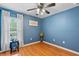 Bright bedroom with wood floors, blue walls, and a window with natural light at 25237 Lexington Oaks Blvd, Wesley Chapel, FL 33544