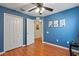 Bedroom with wood floors, blue walls, and access to another room at 25237 Lexington Oaks Blvd, Wesley Chapel, FL 33544