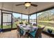 Relaxing screened porch with lake view, wicker furniture, and dining table at 25237 Lexington Oaks Blvd, Wesley Chapel, FL 33544