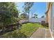 Backyard with grassy area, trees, and a white vinyl fence at 31447 Shaker Cir, Wesley Chapel, FL 33543