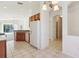 Kitchen area with wood cabinets, appliances, and a hallway at 31447 Shaker Cir, Wesley Chapel, FL 33543