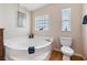 Relaxing bathroom with a garden tub, toilet, and a window at 37539 Gill Ave, Zephyrhills, FL 33541