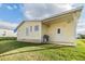 Back exterior view of manufactured home, with covered patio and grassy area at 37539 Gill Ave, Zephyrhills, FL 33541