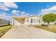 Front view of manufactured home with attached garage and landscaping at 37539 Gill Ave, Zephyrhills, FL 33541