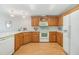 Kitchen with light wood cabinets and white appliances at 37539 Gill Ave, Zephyrhills, FL 33541