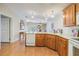 Open kitchen with island, wood cabinets, and white appliances at 37539 Gill Ave, Zephyrhills, FL 33541