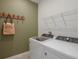 Bright laundry room with Whirlpool washer and dryer and storage shelving at 4177 Feldspar Ln, Spring Hill, FL 34609