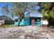 Teal house with red door and a partially landscaped yard at 540 Marlyn Way, Madeira Beach, FL 33708