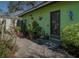 Green house exterior with a lovely garden and flagstone path at 631 San Roy S Dr, Dunedin, FL 34698