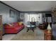 Living room with red couch, coffee table, and large window at 631 San Roy S Dr, Dunedin, FL 34698