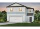Two-story house with light blue siding, white garage door, and landscaping at 6659 Depue Dr, Wesley Chapel, FL 33545