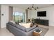 Gathering room with gray sectional sofa and sliding door to backyard at 6659 Depue Dr, Wesley Chapel, FL 33545