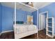 Light blue bedroom with wood floors, a canopy bed, and access to a hallway at 9244 Rhea Dr, Odessa, FL 33556