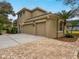 Exterior view of a two-story house with a three car garage at 9244 Rhea Dr, Odessa, FL 33556