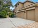 Tan three-car garage with paved driveway at 9244 Rhea Dr, Odessa, FL 33556