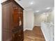Hallway with hardwood floors, white railings, and a decorative wooden cabinet at 9244 Rhea Dr, Odessa, FL 33556