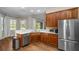 Kitchen features wood cabinets, stainless steel appliances, and hardwood floors at 9244 Rhea Dr, Odessa, FL 33556