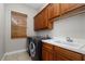 Laundry room with washer, dryer, and wood cabinets at 9244 Rhea Dr, Odessa, FL 33556