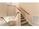 Indoor staircase with wood railing and carpeted steps at 9406 Citrus Glen Pl, Tampa, FL 33618