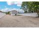 Gravel driveway and backyard with artificial turf and a white fence at 13024 Dania St, Hudson, FL 34667