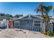 Quaint beach cottage, gray siding, orange door, American flag, crab decor at 13708 Salem St, Madeira Beach, FL 33708