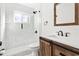 Modern bathroom with glass shower, white tile, and wood vanity at 14198 89Th Ave, Seminole, FL 33776