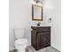 Bathroom with wood vanity, mirror, and white toilet at 14198 89Th Ave, Seminole, FL 33776