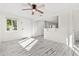 Bright living room features white walls, wood-look floors, and a ceiling fan at 14198 89Th Ave, Seminole, FL 33776