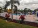 Community pool with surrounding patio furniture and landscaping at 14198 89Th Ave, Seminole, FL 33776