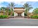 Elegant community clubhouse entrance with palm trees and stone accents at 15902 Golden Lakes Dr, Wimauma, FL 33598