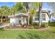 Single-story home with landscaped yard, attached garage, and palm trees at 15902 Golden Lakes Dr, Wimauma, FL 33598