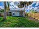 Backyard with grass, palm trees, and wooden fence at 1637 82Nd Street E Ct, Palmetto, FL 34221