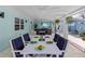 Outdoor dining area with white table and blue chairs near pool at 1832 San Mateo Dr, Dunedin, FL 34698