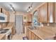 Galley kitchen with wood cabinets, view of dining area at 1849 Bough Ave # D, Clearwater, FL 33760