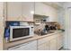 Condo kitchen with white cabinets, double sink, and microwave at 2630 Pearce Dr # 102, Clearwater, FL 33764