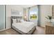 Bright bedroom with a gray upholstered bed and view of backyard at 32660 Rustic Rise Rd, San Antonio, FL 33576