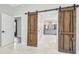 Bathroom with barn doors, double vanity, and grey cabinets at 4825 Scott Rd, Lutz, FL 33558