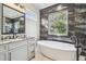 Bathroom with soaking tub, dark tile, and a window at 4825 Scott Rd, Lutz, FL 33558