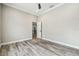 Bright bedroom with wood-look floors and view into the kitchen at 4825 Scott Rd, Lutz, FL 33558