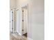 Bright hallway with white doors and wood-look tile floors at 4825 Scott Rd, Lutz, FL 33558