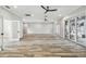 Bright living room with wood-look tile floors, ceiling fans, and pool view at 4825 Scott Rd, Lutz, FL 33558