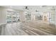 Open living area with wood-look tile floors and pool access at 4825 Scott Rd, Lutz, FL 33558