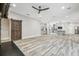 Open living room showcasing a spacious layout, wood-look floors, and a modern kitchen at 4825 Scott Rd, Lutz, FL 33558