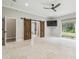 Spacious main bedroom with barn doors, tile floor, and backyard access at 4825 Scott Rd, Lutz, FL 33558
