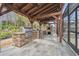 Outdoor kitchen with grill and pizza oven under a wood pergola at 4825 Scott Rd, Lutz, FL 33558